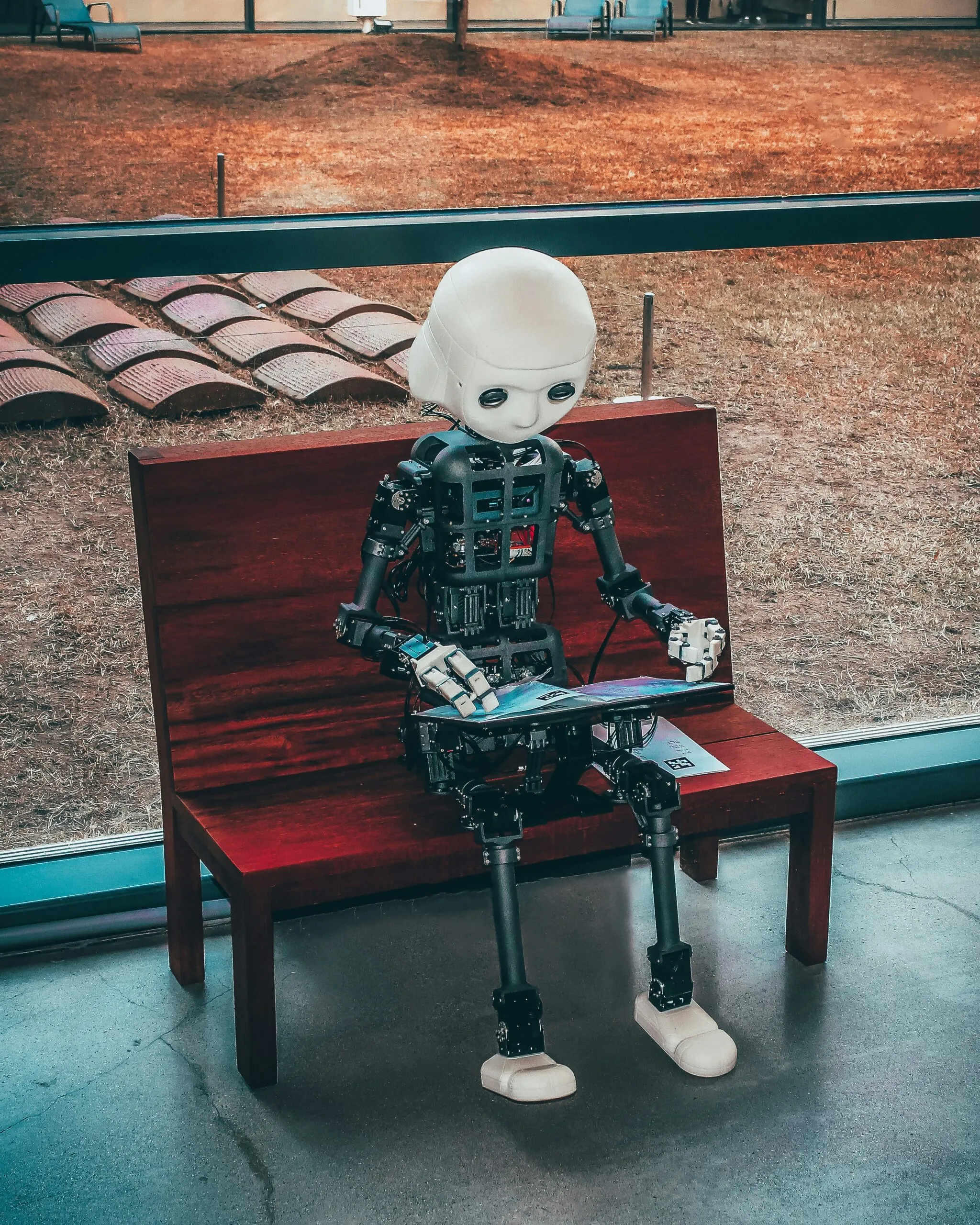 black-and-white-robot-toy-on-red-wooden-table-scaled